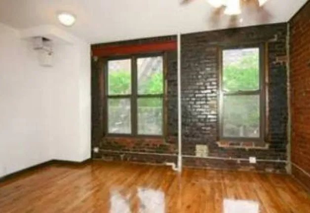 Exposed-brick living room with refinished wood floors at 342 East 13th Street